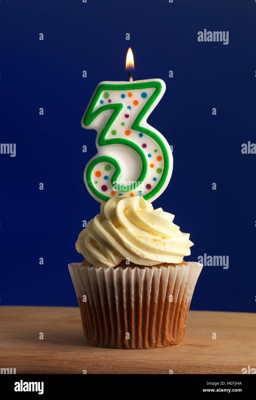 Cupcake with sparkling candle for 39th birthday or anniversary with big  number in white with yellow streamers on blue table with dark background  full Stock Photo - Alamy