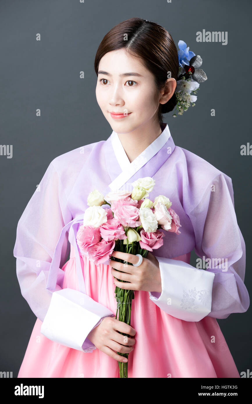 Young Woman In Traditional Korean Clothes Holding Flowers Stock