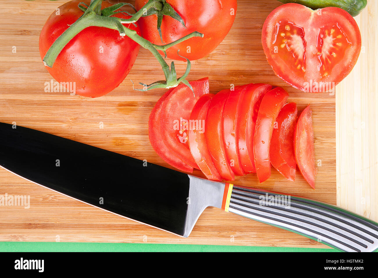 whole and sliced tomato on a chopping board Stock Photo - Alamy