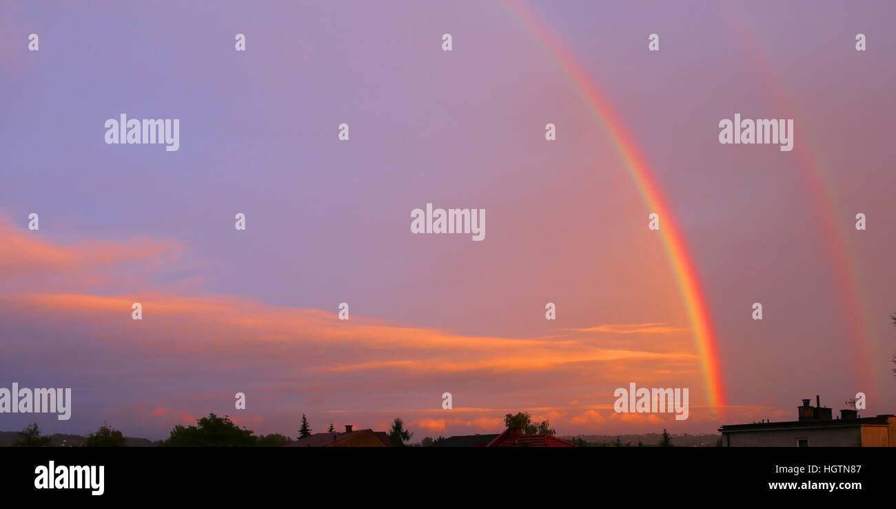 beautiful double rainbow at sunset with sky and clouds Stock Photo - Alamy