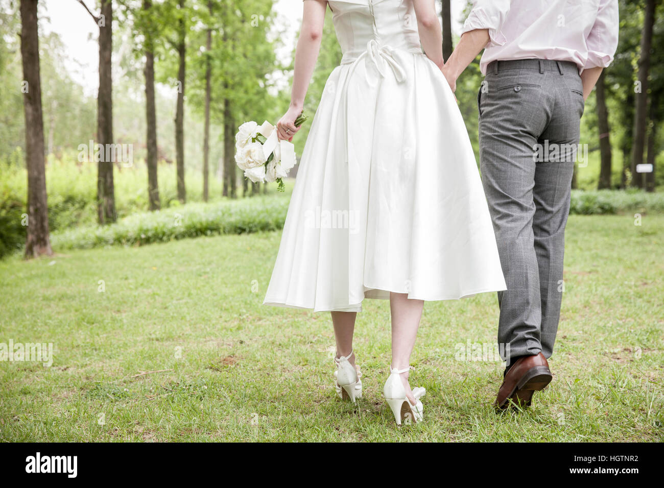 Back of young romantic wedding couple walking outdoors Stock Photo - Alamy