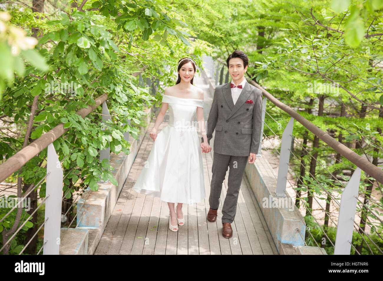 Young romantic wedding couple posing holding hands outdoors Stock Photo ...