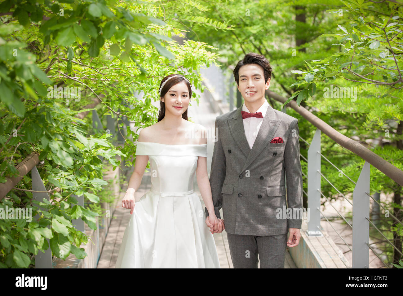 Young romantic wedding couple holding hands outdoors Stock Photo - Alamy