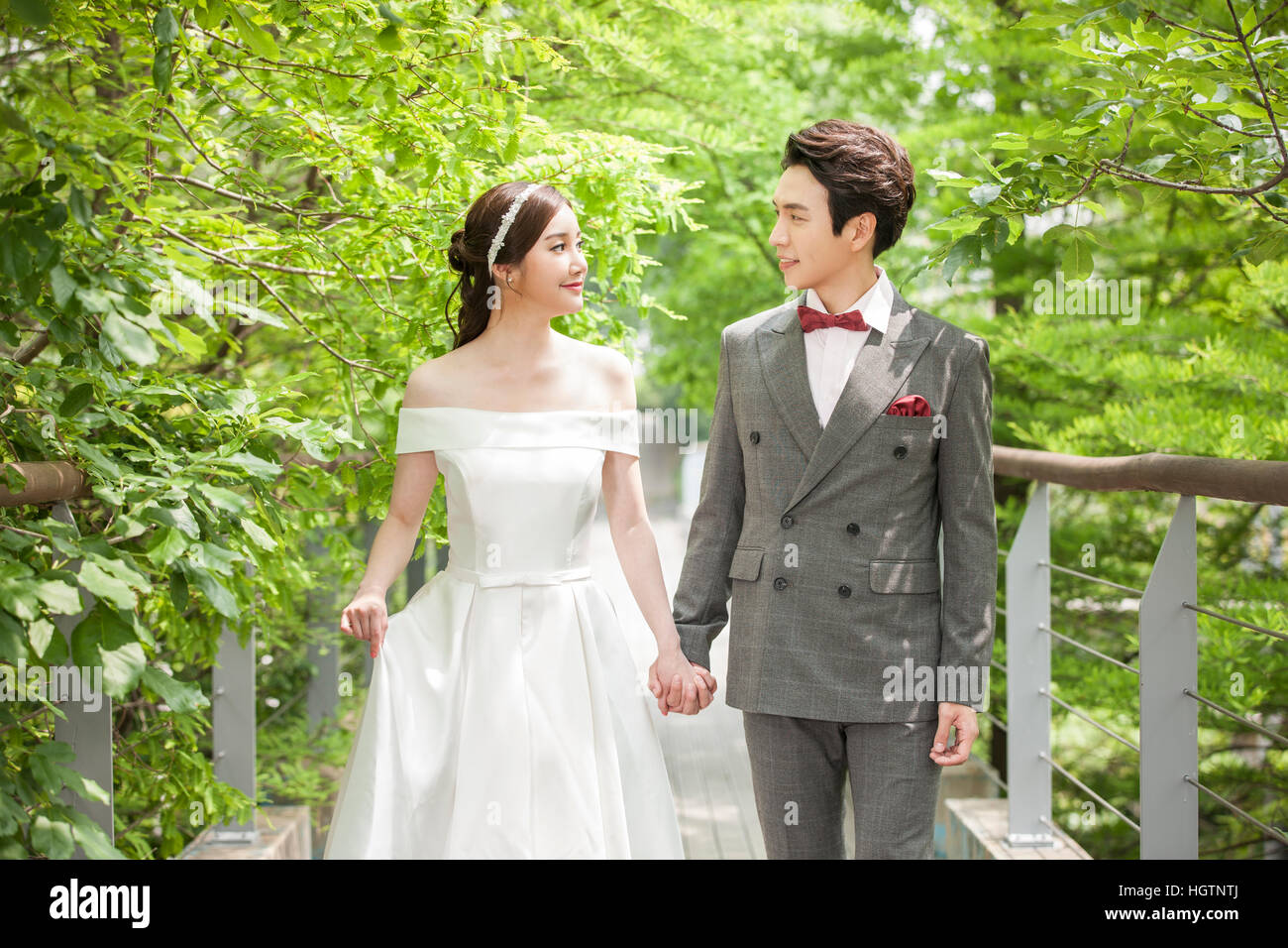 Young romantic wedding couple holding hands face to face outdoors Stock Photo