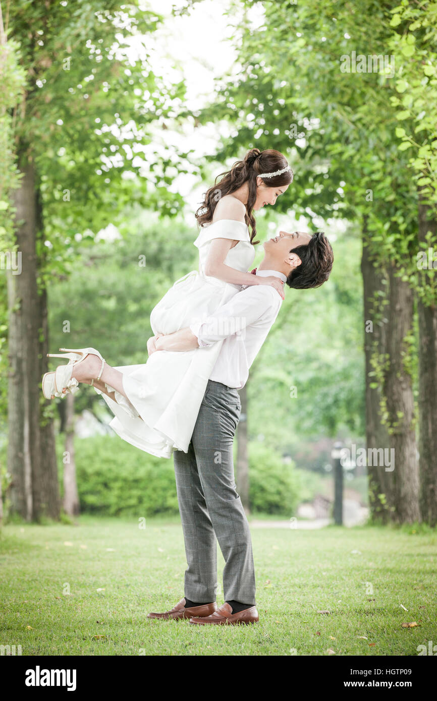 Side view of young romantic wedding couple holding face to face outdoors  Stock Photo - Alamy