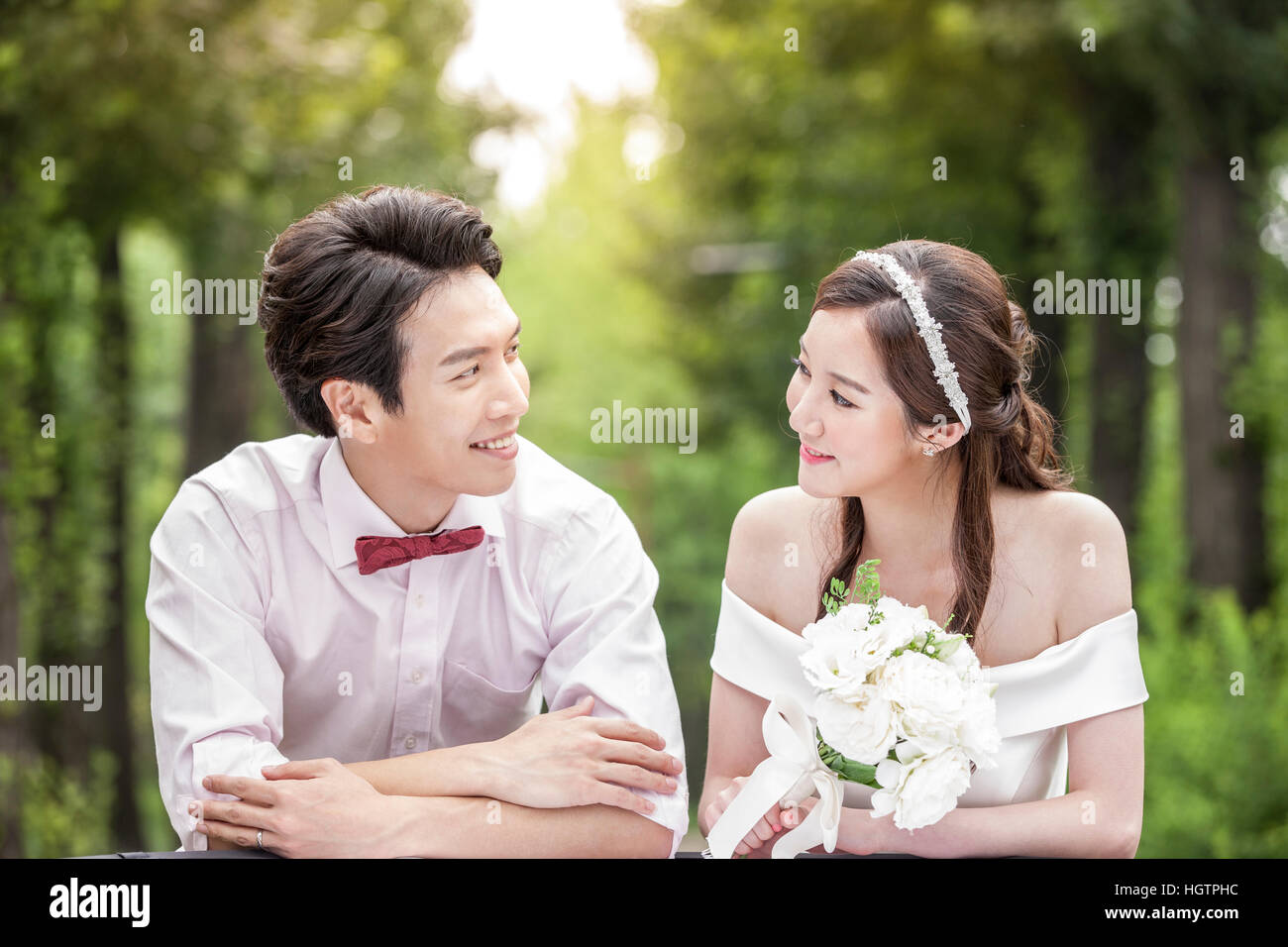Portrait of young romantic wedding couple face to face outdoors ...