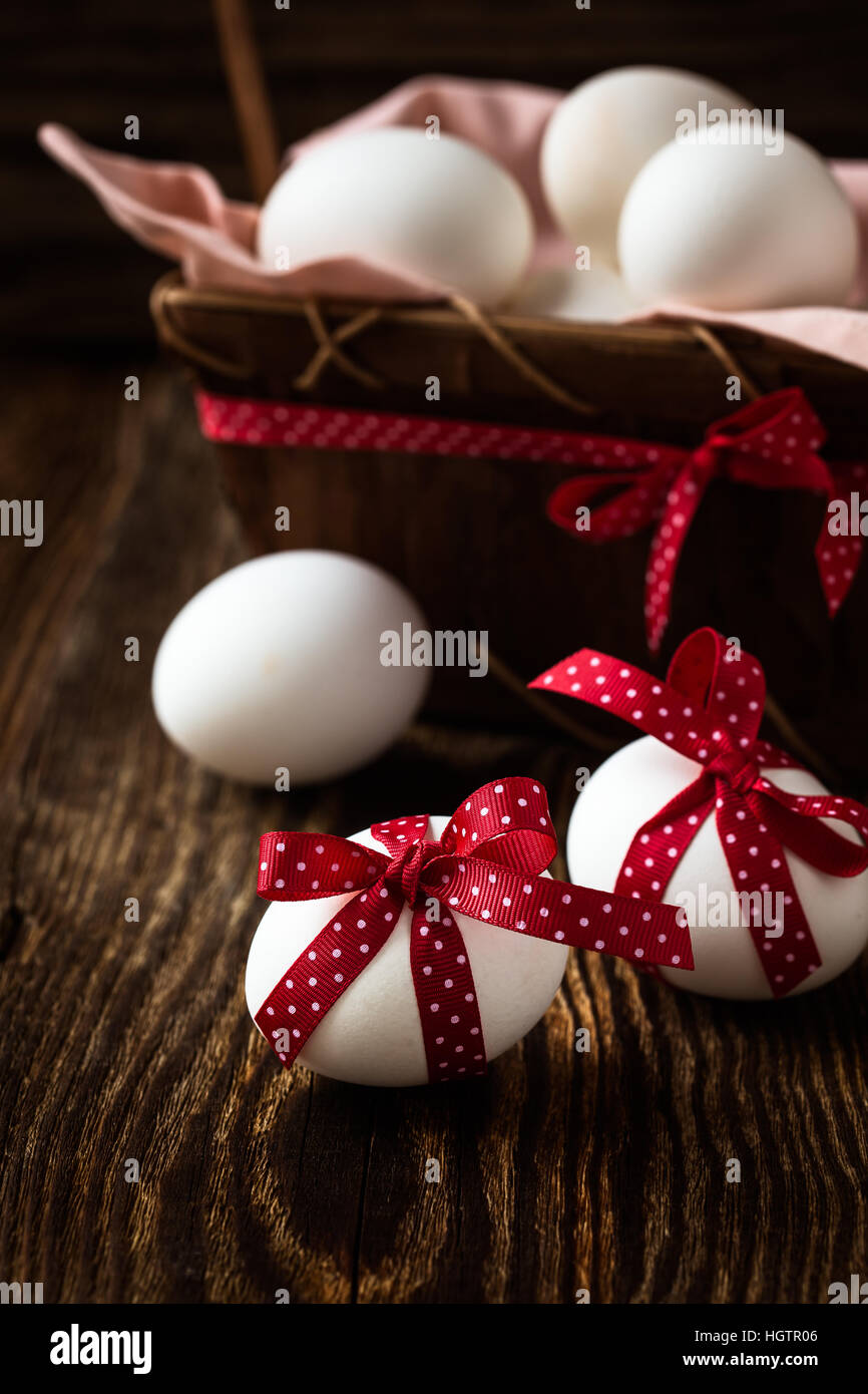 White easter eggs with red bows on rustic background Stock Photo - Alamy