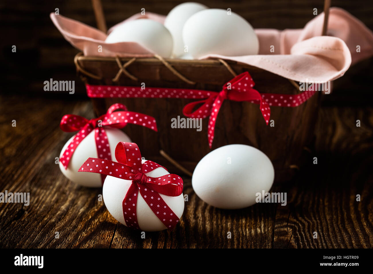 White easter eggs with red bows on rustic background Stock Photo - Alamy