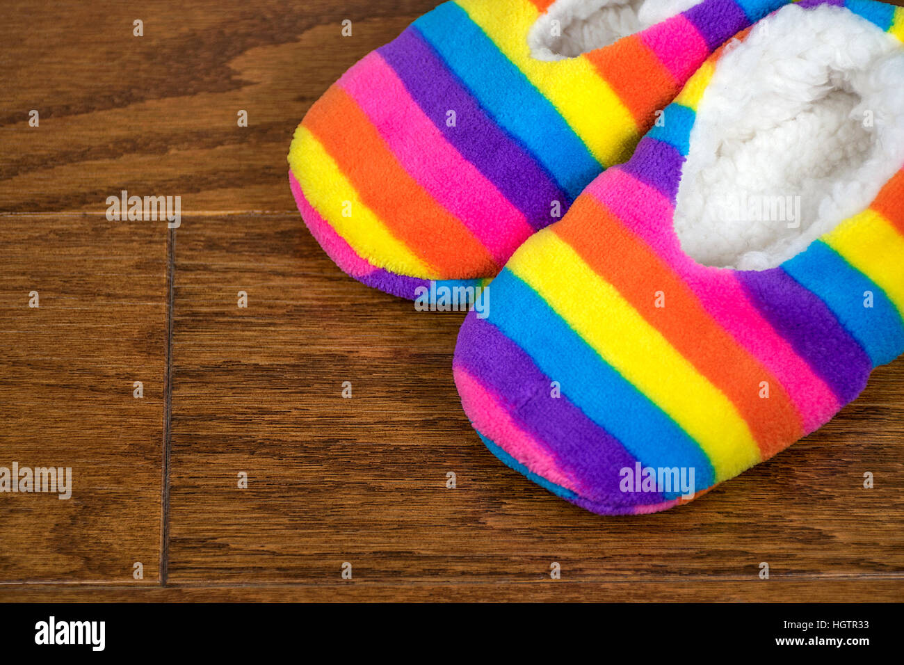 rainbow striped bedroom slippers on wood floor Stock Photo