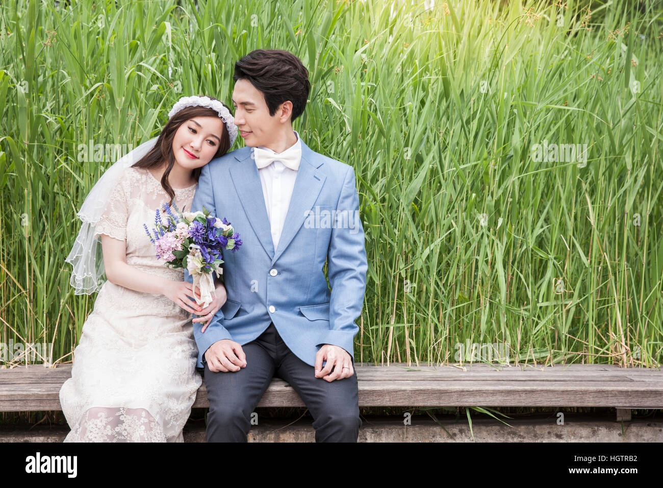 Young smiling wedding couple posing outdoors Stock Photo - Alamy