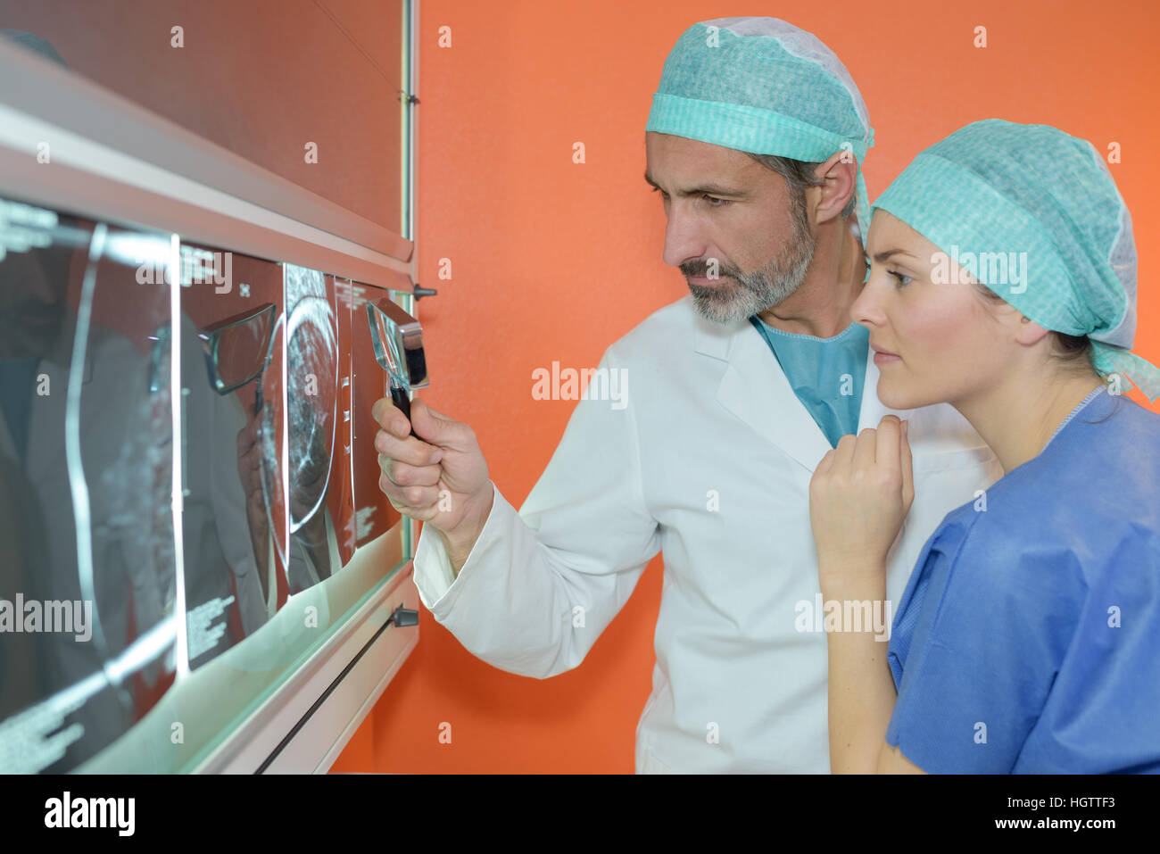 Doctor looking at xray with magnifying glass Stock Photo Alamy