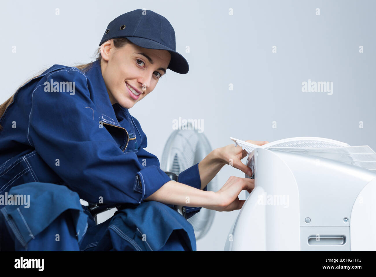 Woman working on air conditioning unit Stock Photo