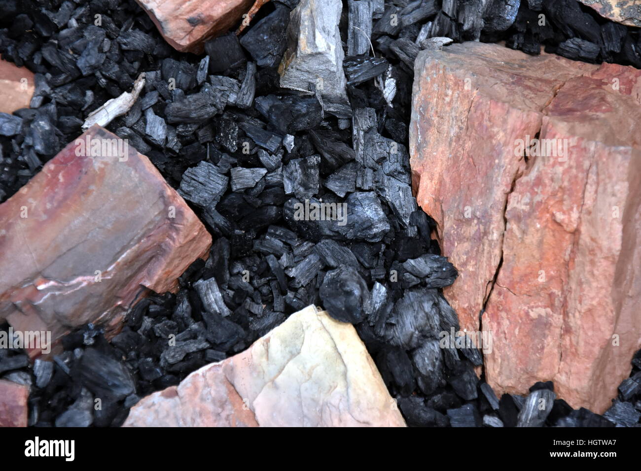 Extinct coals after bonfire surrounded with rocks. Ashes and cinders