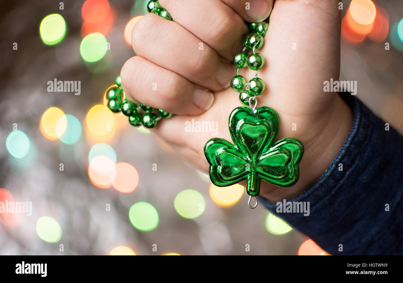 Male hand holding green clover necklace. St Patricks day preparation Stock Photo