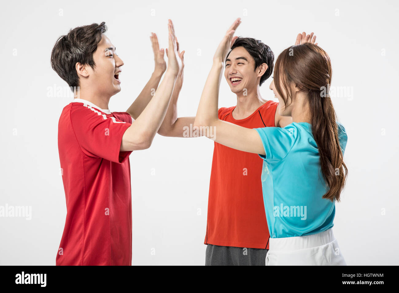 Young smiling sports players slapping high fives Stock Photo