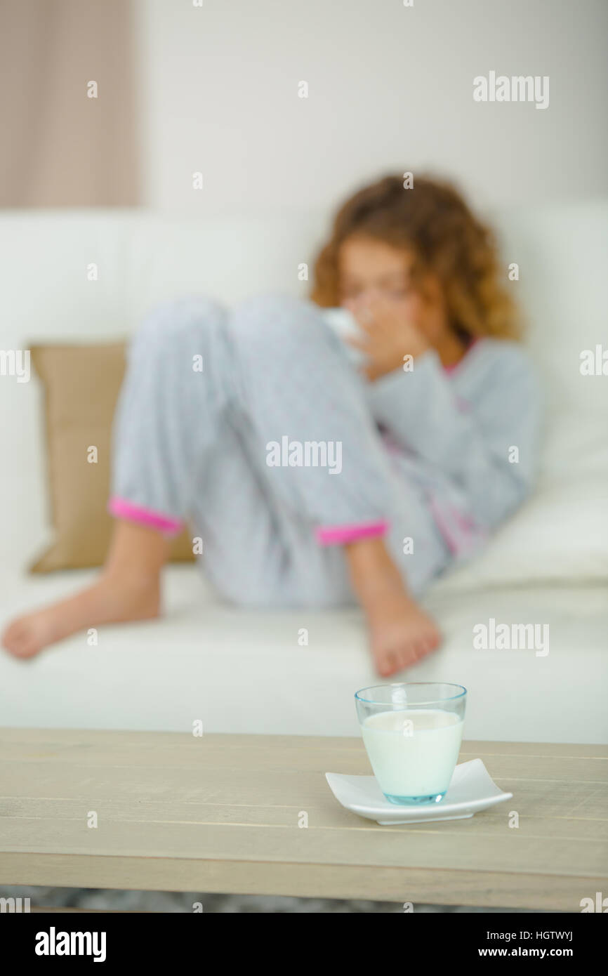 School girl on couch, glass of milk on table Stock Photo Alamy