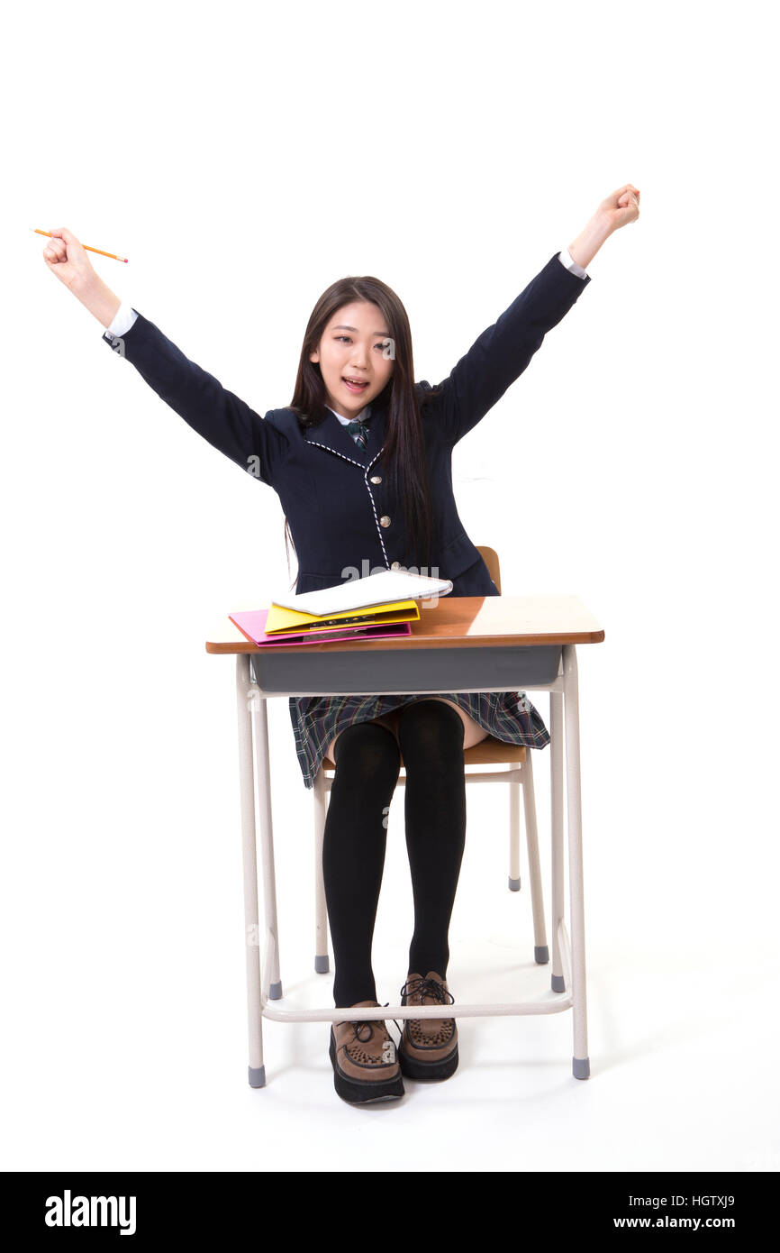 Smiling Korean high school girl cheering sitting at desk Stock Photo ...