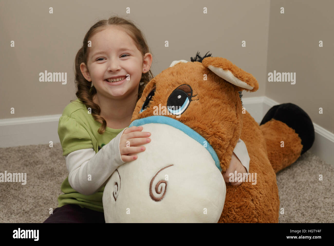 a smiling little girl with a huge stuffed animal Stock Photo - Alamy