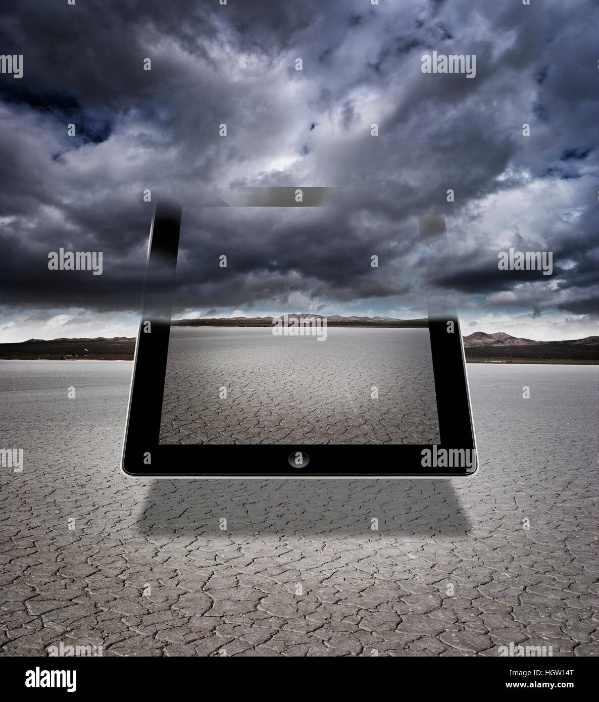 Composite Of A Digital Tablet With Storm Clouds In A Dry Lakebed Stock Photo