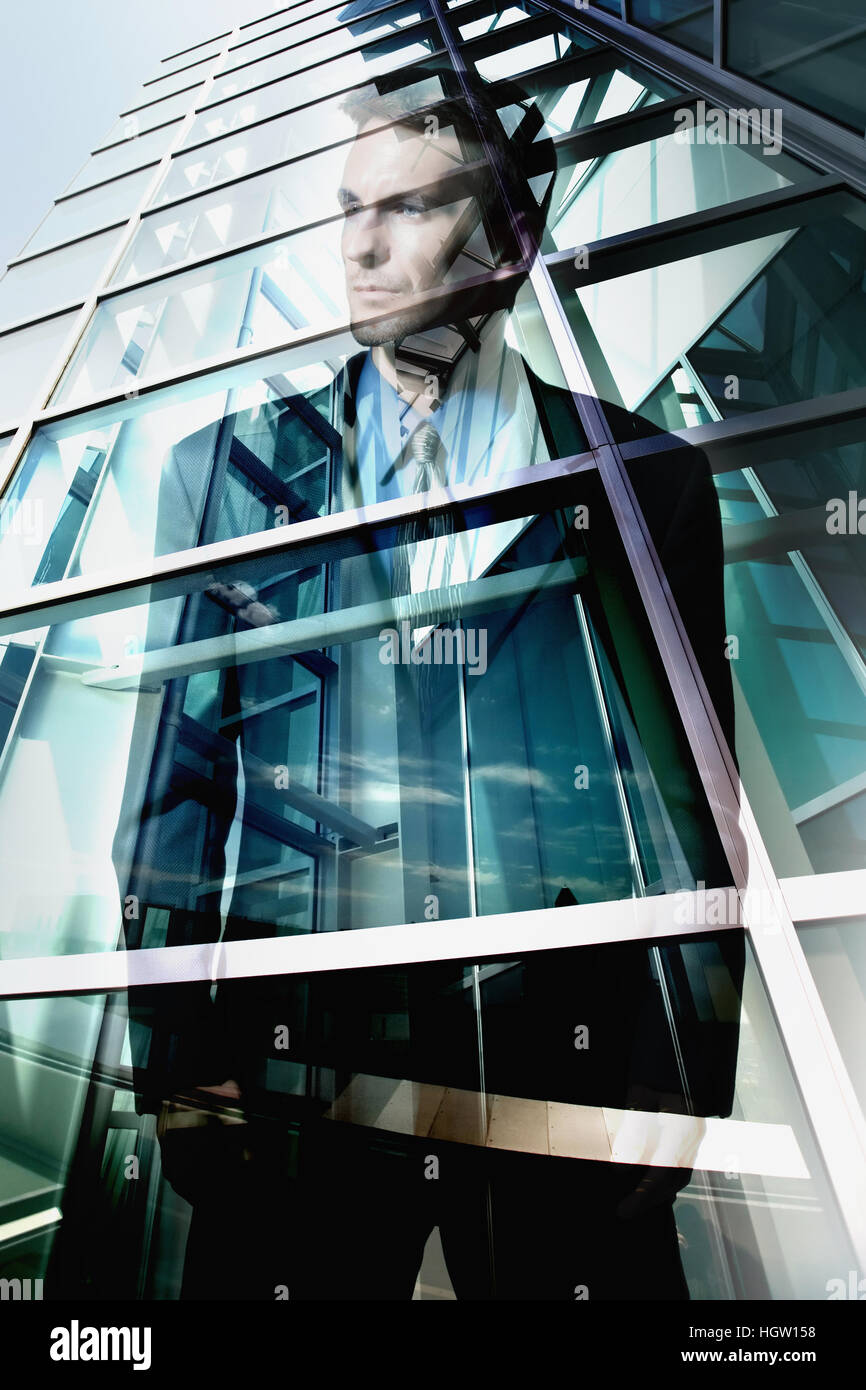 Reflection Of Businessman In Office Windows Stock Photo