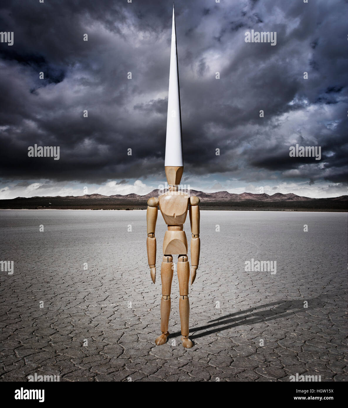 Artist Manikin With A Dunce Cap In A Dry Lake Bed With Storm Clouds Stock Photo