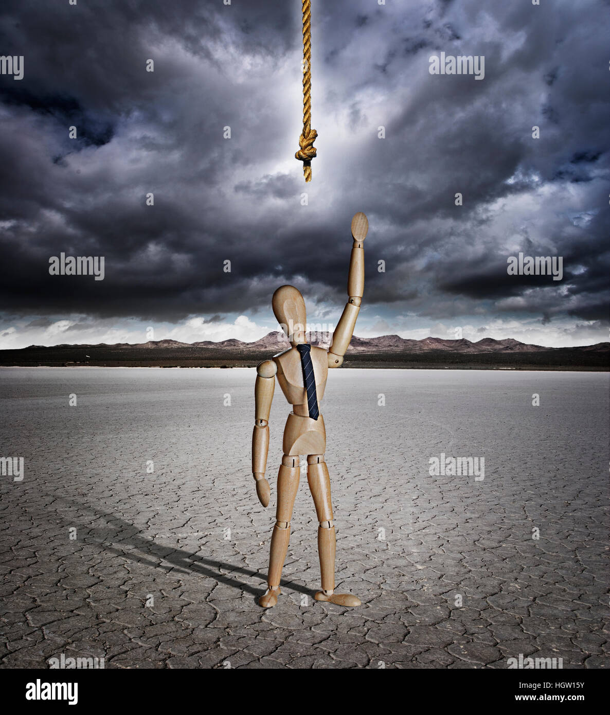 Artist Manikin Reaching For A Rope In A Dry Lake Bed With Storm Clouds Stock Photo