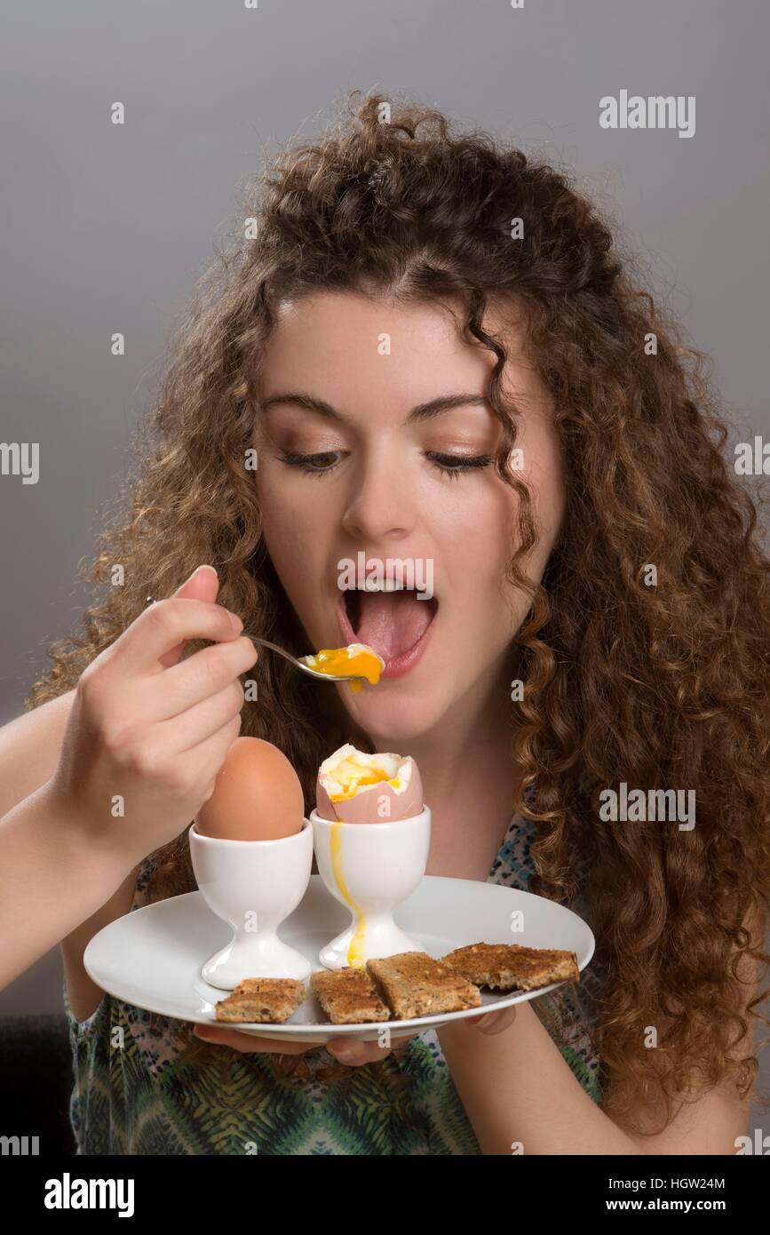 Young girl eating boiled eggs for breakfast Stock Photo Alamy