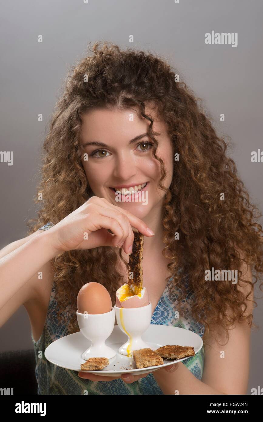 Young girl dipping a slice of toast into boiled hires stock