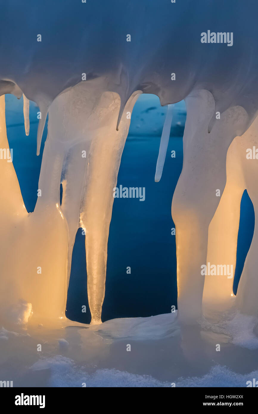 Thick ice formed from waves splashing on handrail near Grand Haven