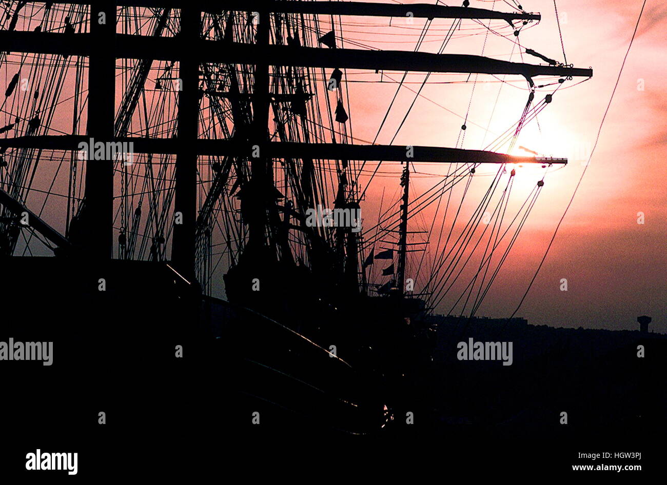 AJAXNETPHOTO. 1989. ROUEN, FRANCE. - TALL SHIPS GATHER ON SEINE - SUN SETS BEHIND THE YARDS AND MASTS OF TALL SHIPS MOORED IN THE CITY FOR THE 'VOILE DE LA LIBERTE' PARADE OF SAIL.  PHOTO:JONATHAN EASTLAND/AJAX  REF:M7 1989 Stock Photo