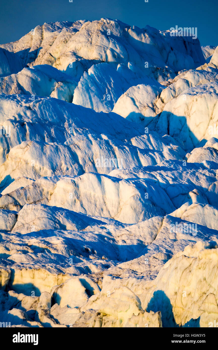 Pastel hues across a field of crevasse and pressure ridges in the fracture zone of a glacier. Stock Photo