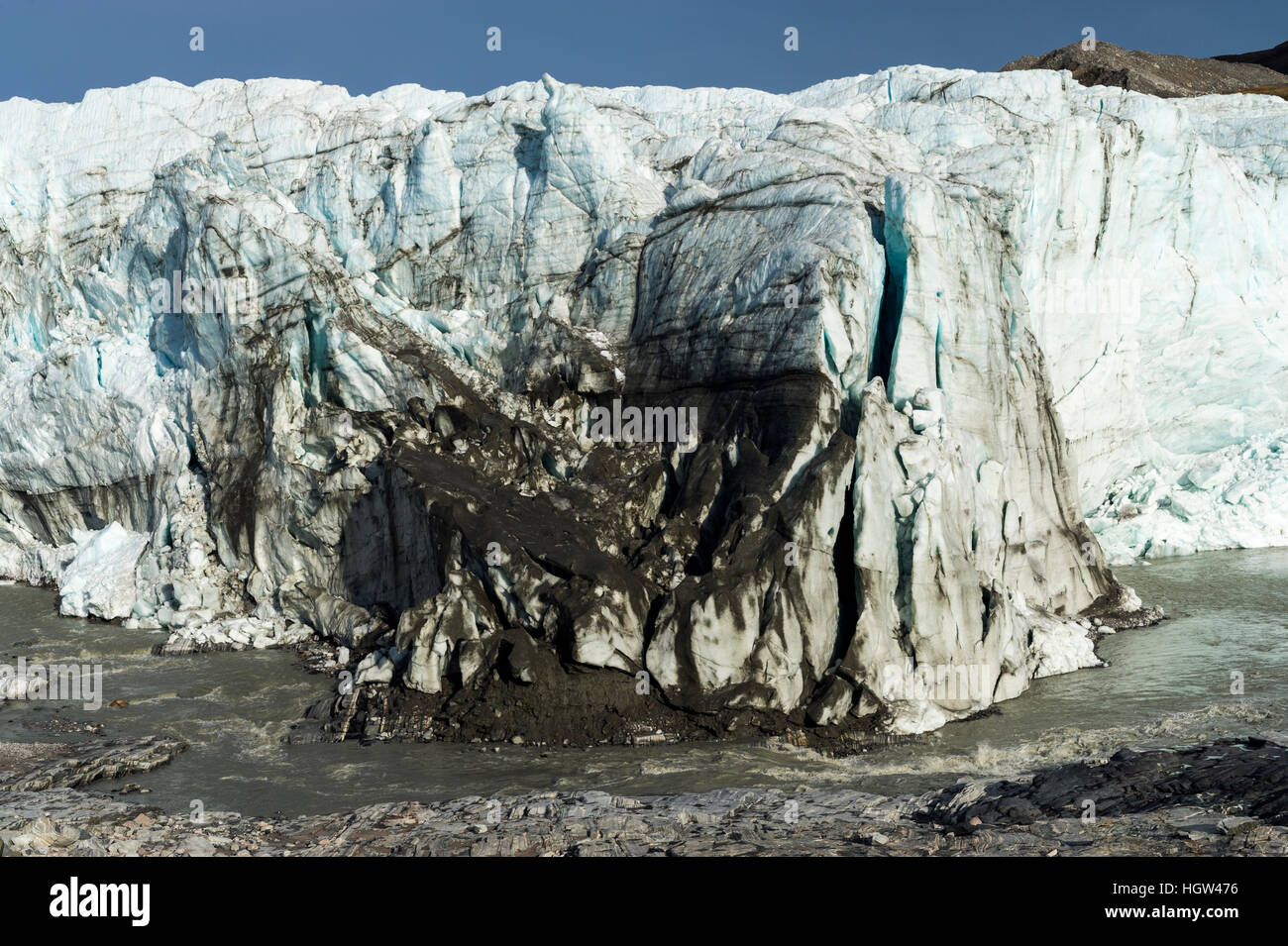 Erosion from ice against rock deposits silt and soil sediment on the face of a glacier fracture zone. Stock Photo