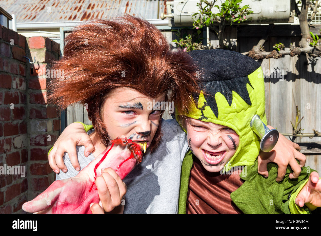 Two friends, a werewolf and Frankenstein, hug each other at a monster party. Stock Photo