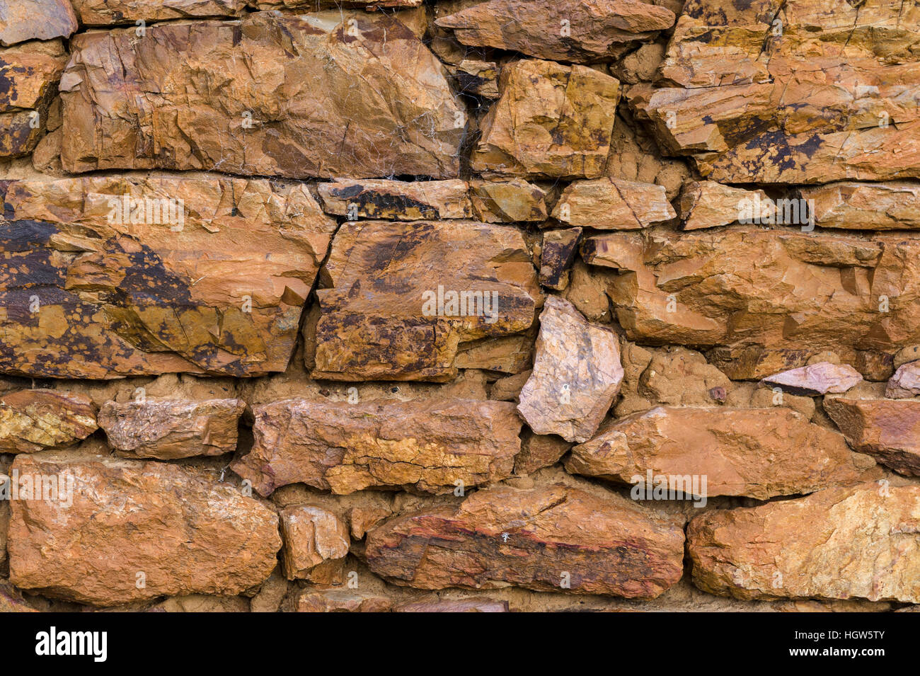 The stone wall of a 19th century grain storage shed built from locally quarried stones and timber. Stock Photo
