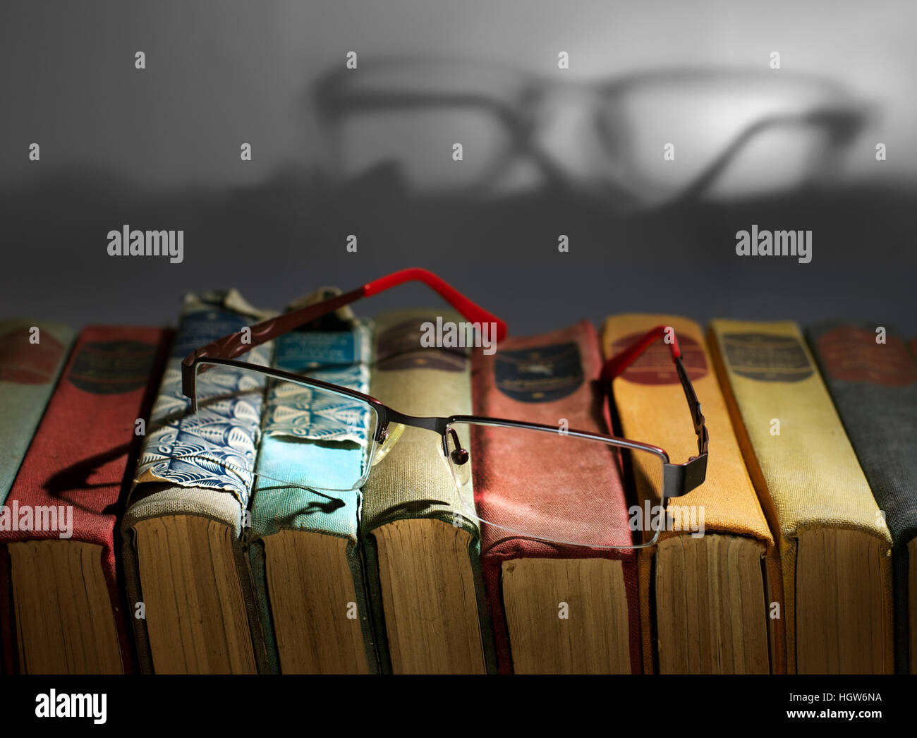 Reading concept. Pair of glasses on a stack of books. Stock Photo