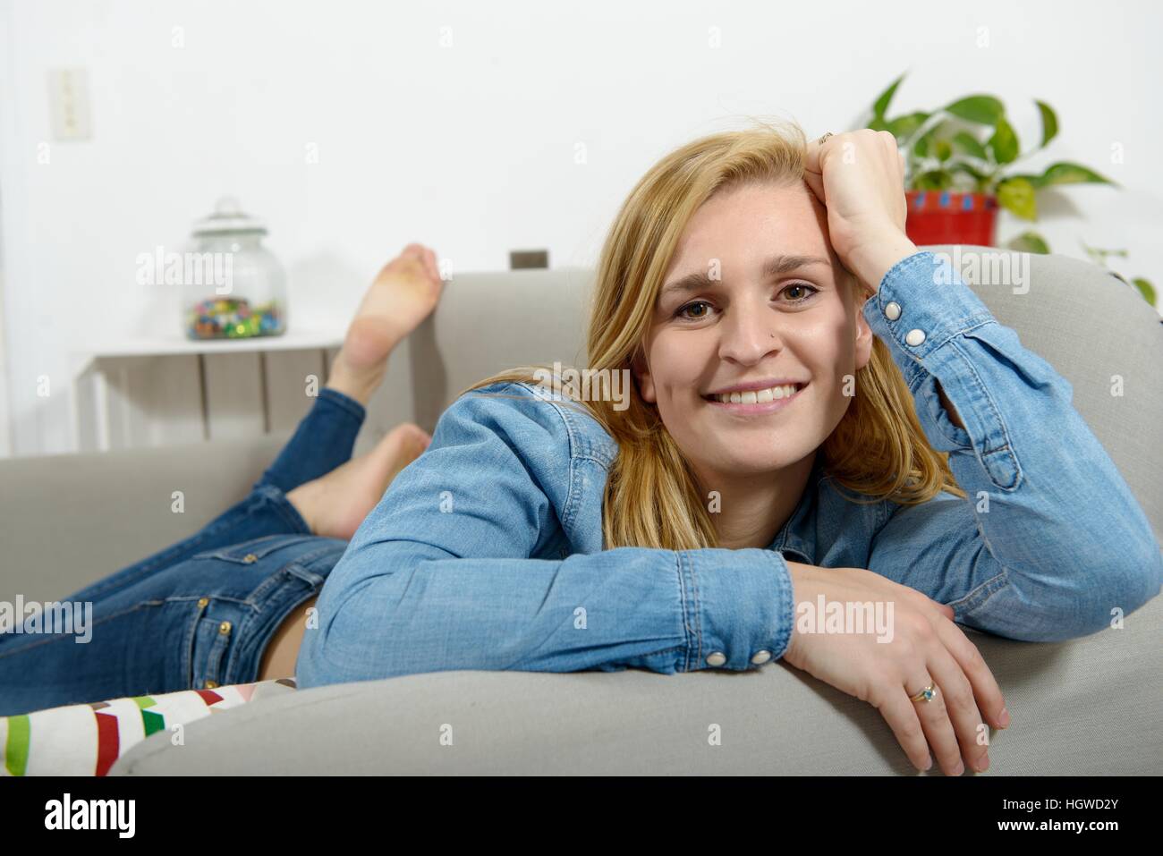beautiful young blonde woman relaxing on sofa Stock Photo - Alamy