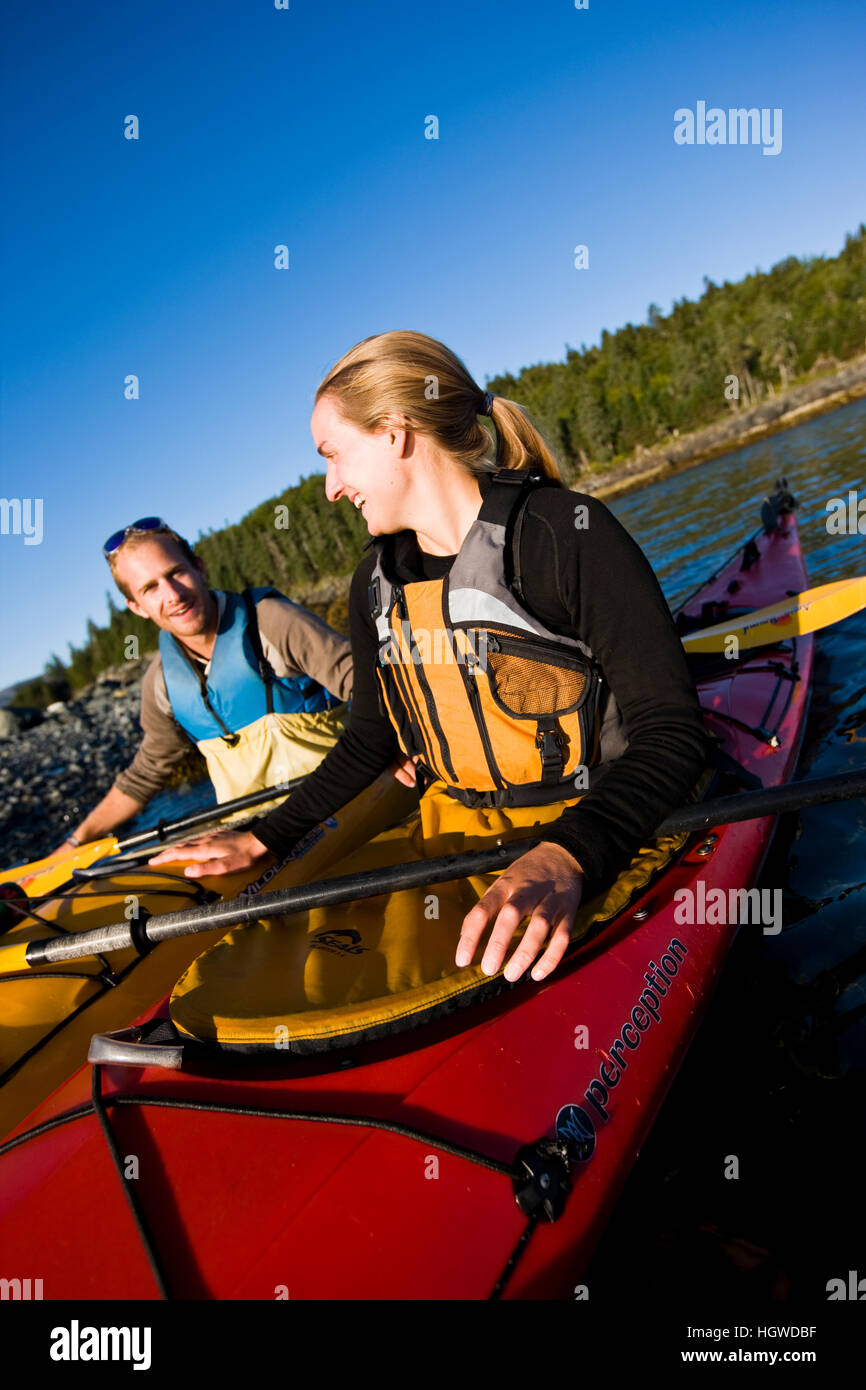 A young couple sea kayaking near the Porcupine Islands in Maine's