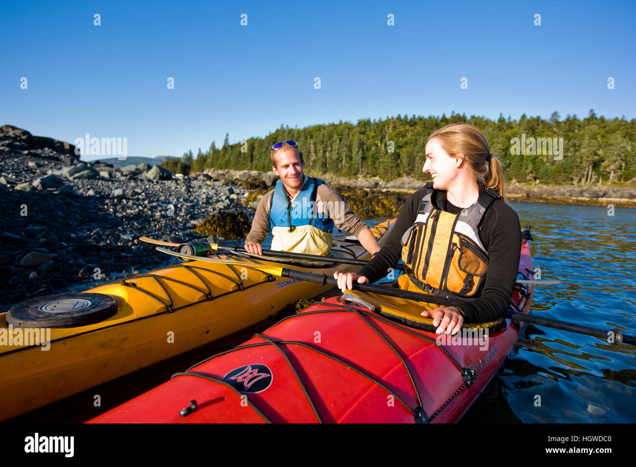 A young couple sea kayaking near the Porcupine Islands in Maine's