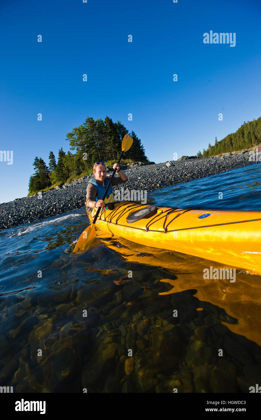 A man sea kayaking near the Porcupine Islands in Maine's Acadia