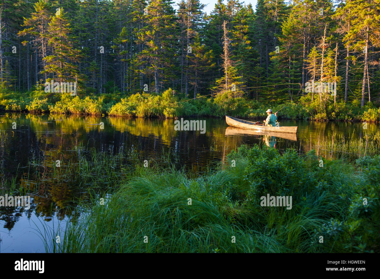 A man flyfishing on Little Berry Pond in Maine's Northern Forest. Cold
