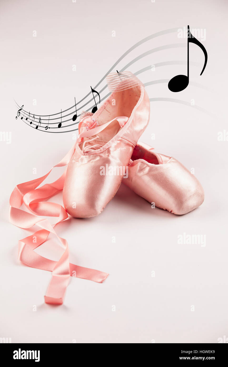 Pink Ballet shoes on white background with musical notes in the background. Stock Photo