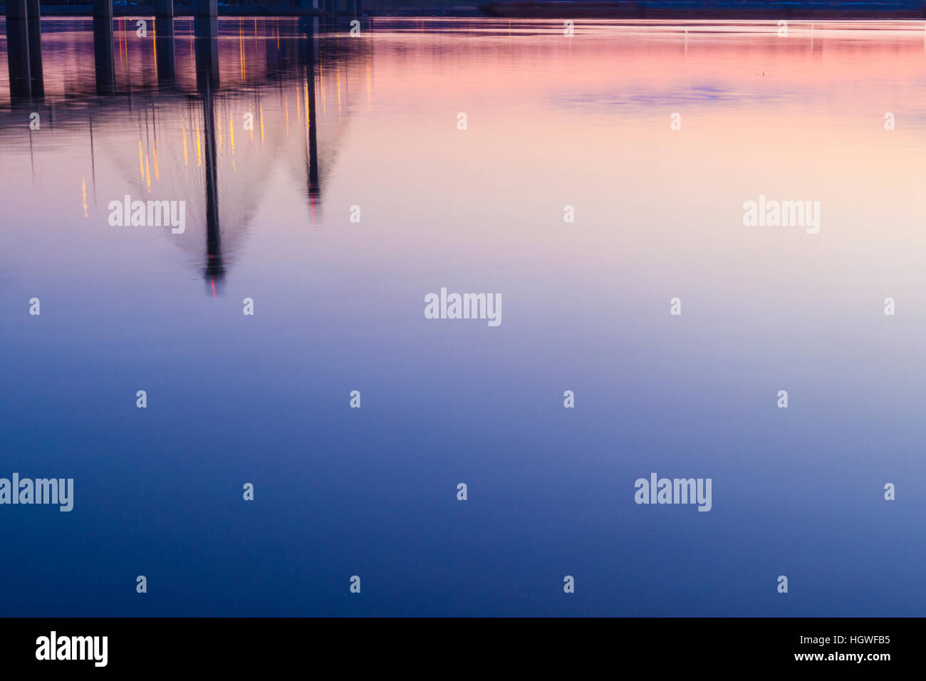 The Clark Bridge reflects in the Mississippi River at dawn in West