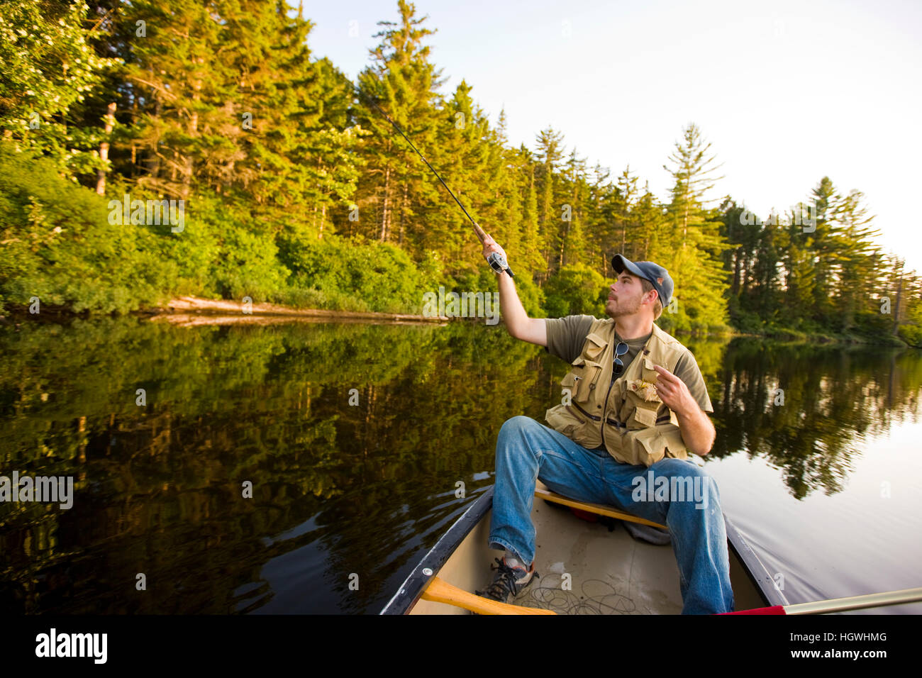 A man flyfishing from a canoe on Little Greenough Pond in Errol, New
