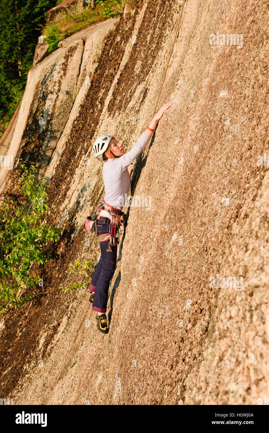A woman rock climbing near the top of Cathedral Ledge. Echo Lake State