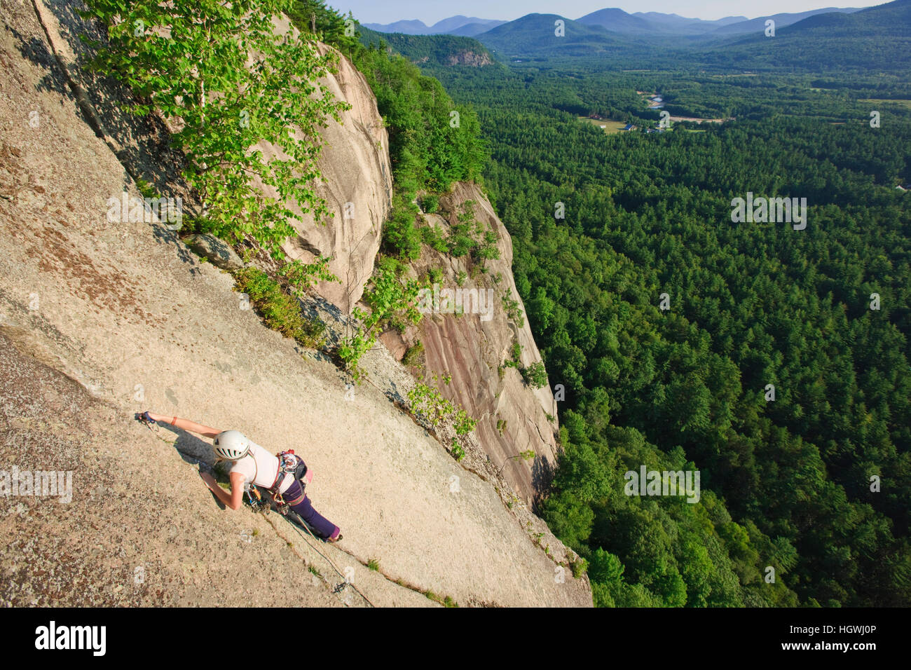 A woman leads a climb of 'Top of the Prow' on Cathedral Ledge.  Echo Lake State Park in North Conway, New Hampshire.  White Mountains. Stock Photo