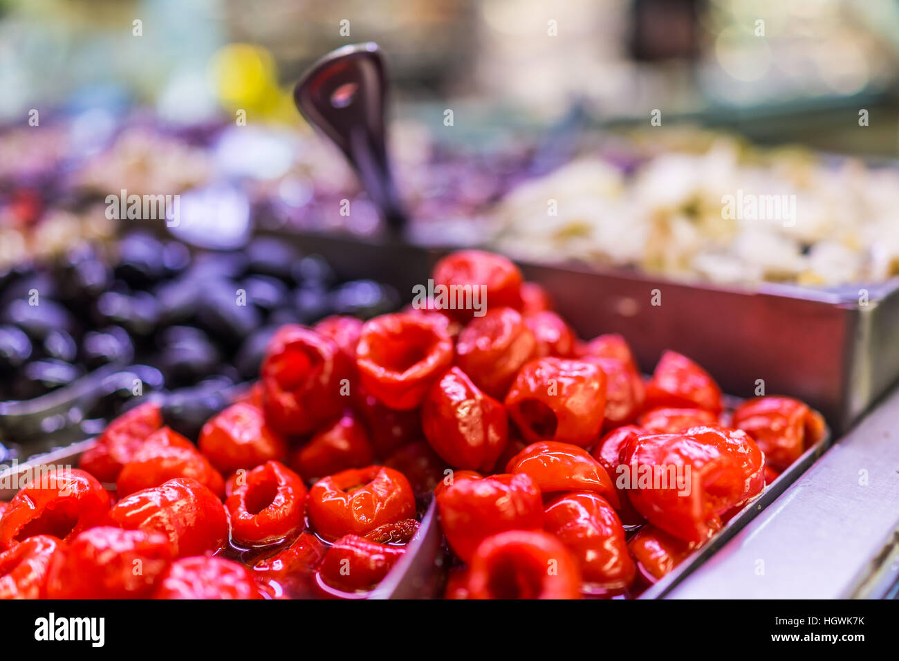Marinated small red peppers in olive bar macro closeup showing detail