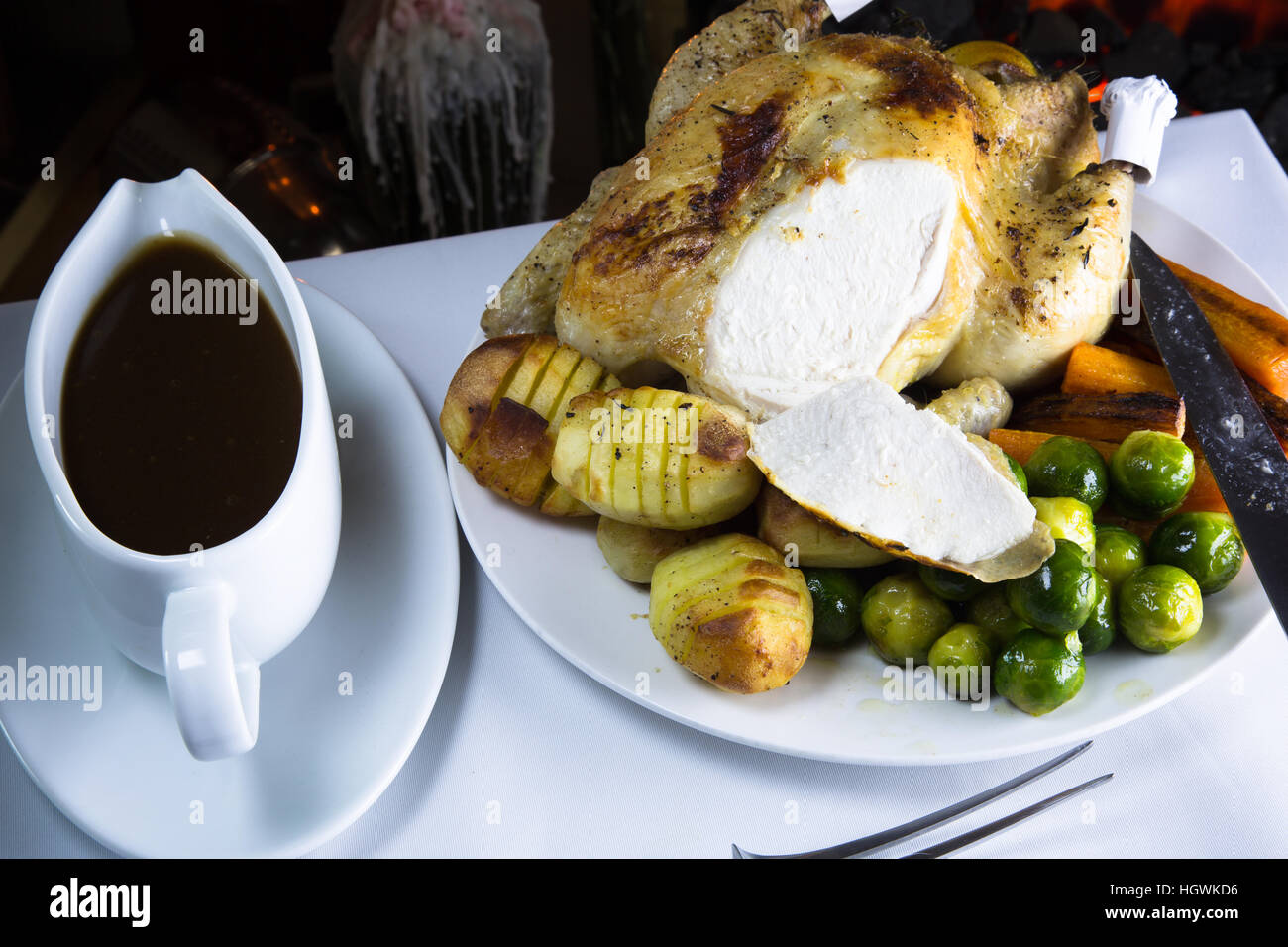 Whole Roast Chicken with potatoes and fresh cooked vegetables ready for serving. Stock Photo
