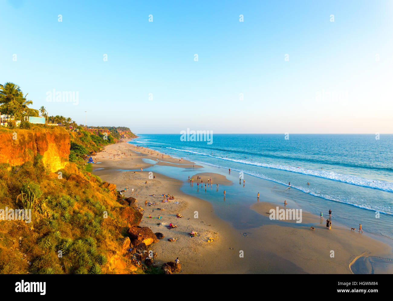 High angle view of sandy beach at low tide and ocean from cliffs on a clear, blue sky day in Varkala, Kerala, India. Horizontal Stock Photo