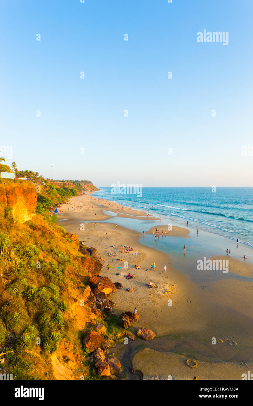 High angle view of sandy beach at low tide and ocean from cliffs on a clear, blue sky day in Varkala, Kerala, India. Vertical Stock Photo
