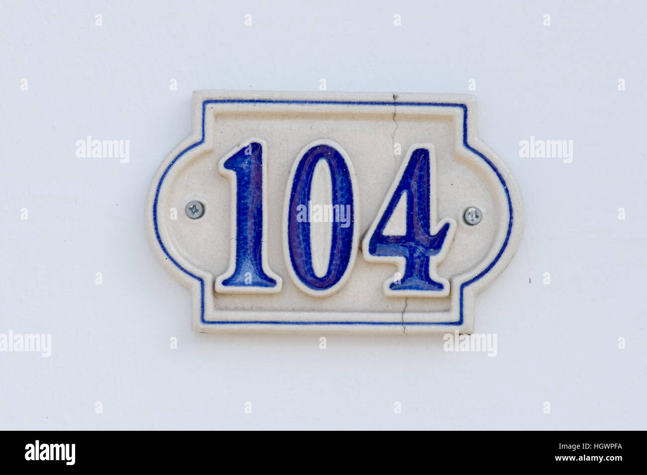 House Number 104 sign - cracked tile Stock Photo